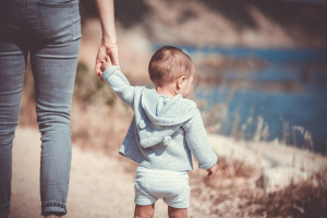 a toddler holding hands with an adult