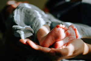 newborn feet cradled in adult hands