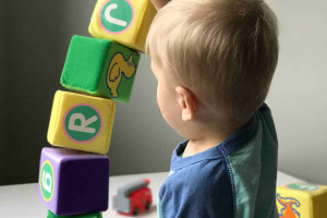 toddler playing with stacking blocks