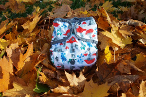 pocket diaper with mushroom print on a pile of autumn leaves